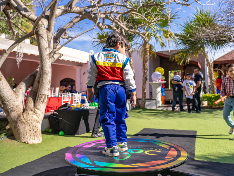 Guest standing on a spinning 360 video booth platform at an outdoor event